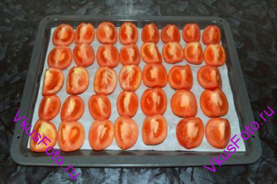 Разрезать помидоры на 4 части и разложить на противень.