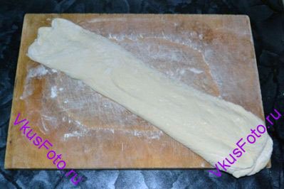 Когда заготовки увеличатся в объеме, переложить их на лопатку или доску швом вниз и растянуть тесто, придавая ему форму тапка.