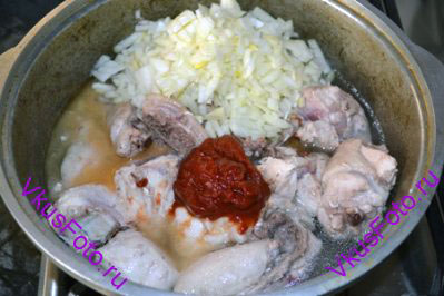К курице положить лук, томатную пасту, уксус и соль.
