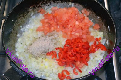 К луку добавить помидор, перец чили и молотые специи. Жарить 5 минут.