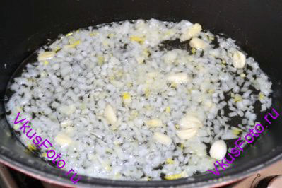 В кастрюле с толстым дном разогреть масло и обжарить лук и чеснок до мягкости 5-7 минут.