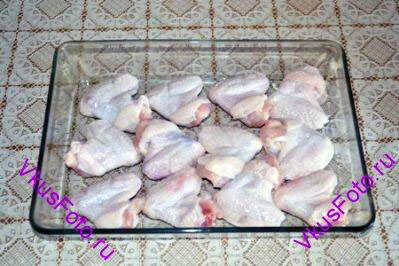 Куриные крылышки уложить в жаропрочную посуду для запекания, посолить, поперчить. 