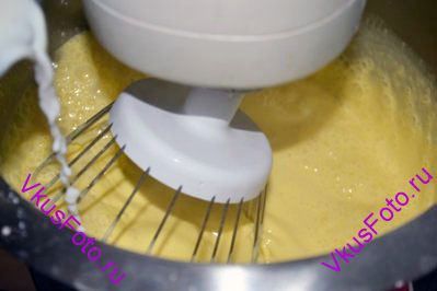 Пока взбиваются желтки, снова довести молоко до кипения и вынуть стручок ванили. 
Горячее молоко тонкой струйкой влить в желтки не переставая взбивать. 
