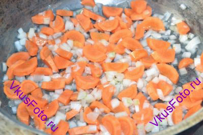В сотейнике или в кастрюле с толстым дном разогреть растительное масло. Положить лук и морковь и жарить примерно 5 минут.