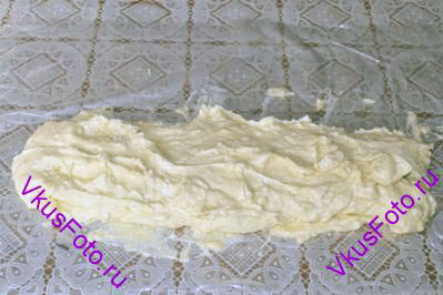 Выложить тесто для печенья на плотную полиэтиленовую пленку.