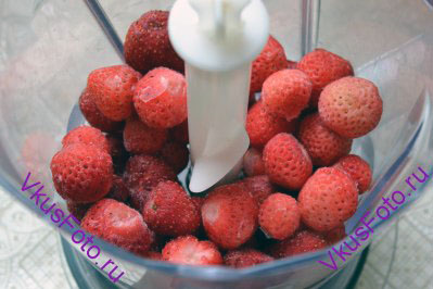 Замороженные ягоды клубники сложить в блендер или кухонный комбайн.