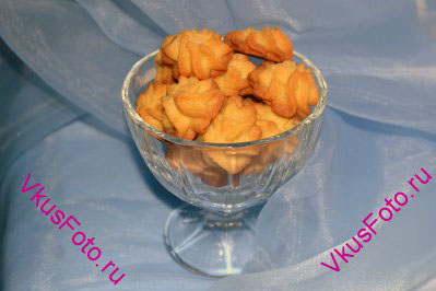 Перекладываем Ванильное печенье с кукурузной мукой в вазочку. При желании печенье можно дополнить сахарными украшениями.